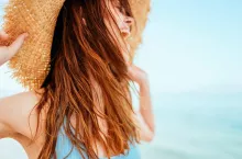 Włosy nie lubią plażowania w pełnym słońcu. Warto je chronić pod nakryciem głowy i stosować specjalne produkty do rozpylania z filtrami UV