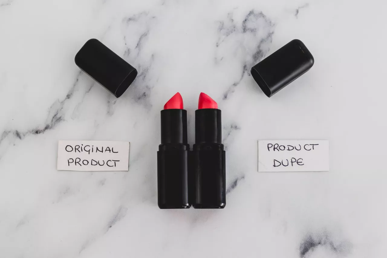 beauty industry competition conceptual still-life, two identhical looking lipsticks with Original Product and Product Dupe labels