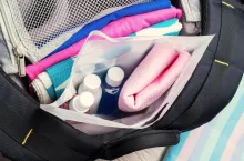 Set of travel bottles and towel in plastic bag