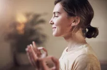 Woman, person and meditation with lotus for yoga with holistic wellness, mental health and healing in class. Girl, yogi and posture for mindfulness, stress relief or zen with eyes closed and happy